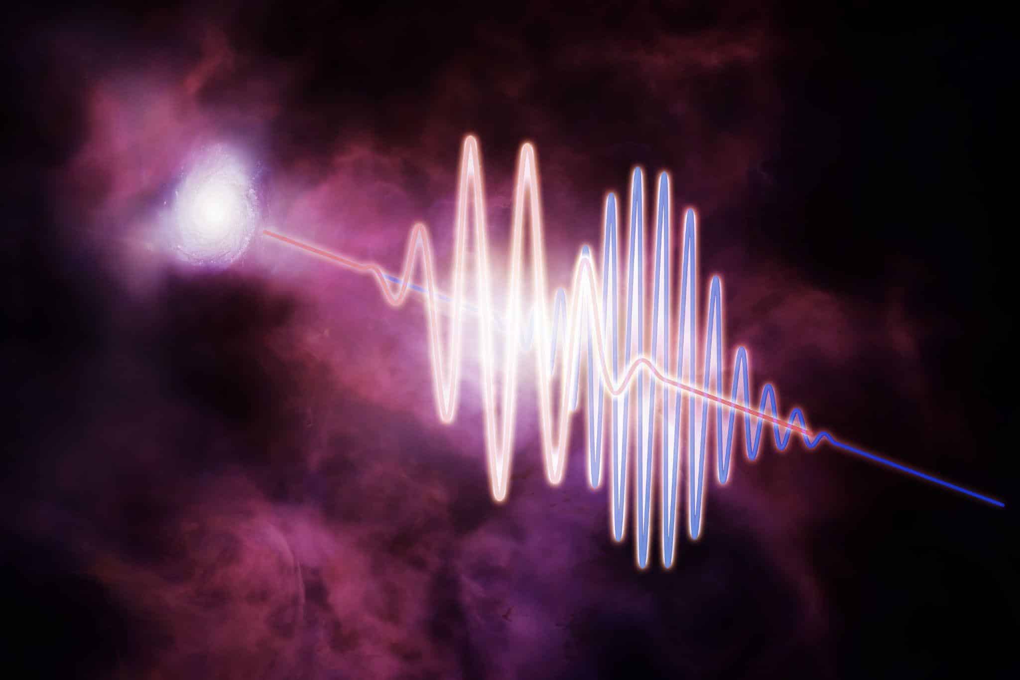 Быстрый радиовсплеск, «летящий» сквозь «дымку» между галактиками, в представлении художника. На иллюстрации видно, как радиоволны с большой длиной волны (красные) замедлились сильнее, чем короткие («голубые») радиоволны. Измеряя это замедление, ученые рассчитали количество вещества в межгалактическом пространстве / © Melissa Weiss, CfA