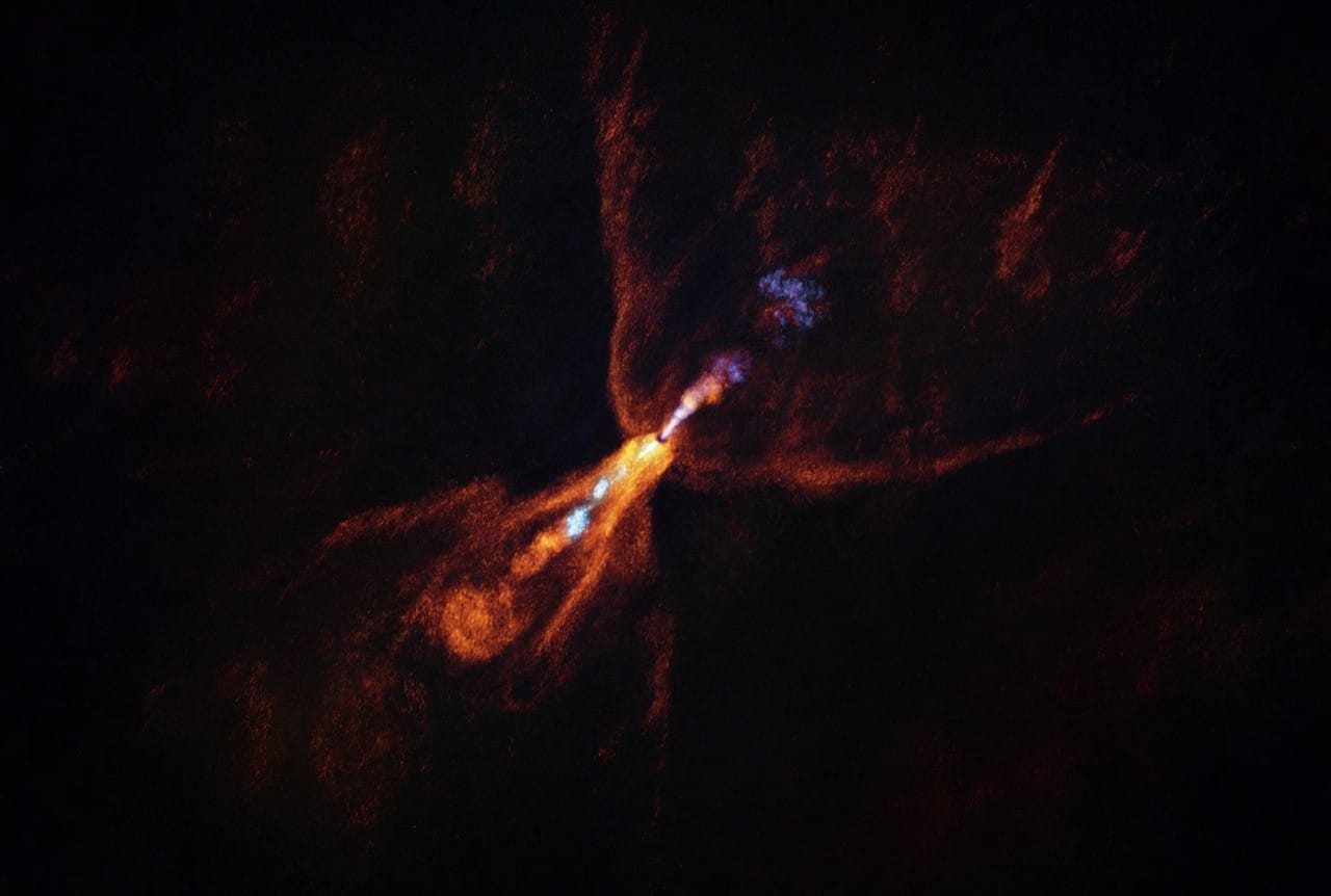 Молодая звезда HOPS-315. Снимок сделан комплексом радиотелескопов ALMA. «Всполохи» на снимке — звездный ветер. Оранжевым «раскрашены» молекулы монооксида углерода, голубым — монооксида кремния. На этом снимке не виден газовый диск, в котором начали формироваться твердые крупицы минералов — первые «кирпичики» планет / © ALMA(ESO/NAOJ/NRAO)/M. McClure et al.